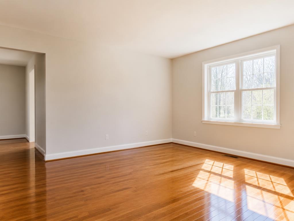 Empty room with gleaming hardwood floors after a move-out cleaning